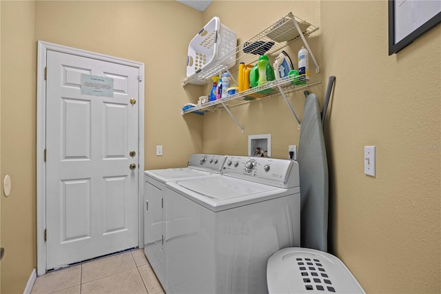 washroom featuring washer hookup, light tile flooring, and washing machine and dryer