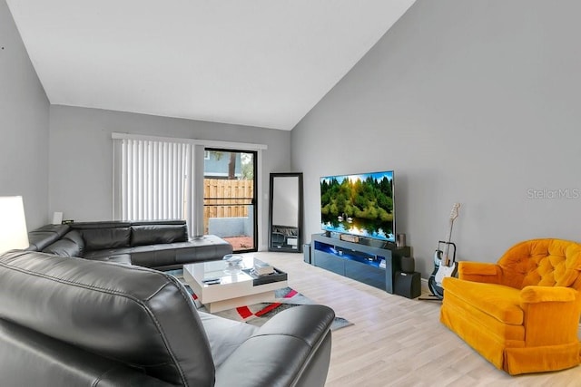 living area with high vaulted ceiling and wood finished floors