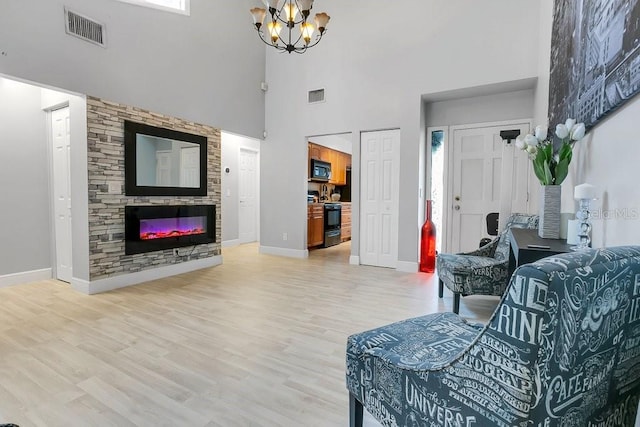 living area with light wood finished floors, baseboards, a fireplace, and visible vents