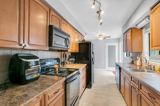 kitchen with black appliances, tasteful backsplash, ceiling fan, and a sink