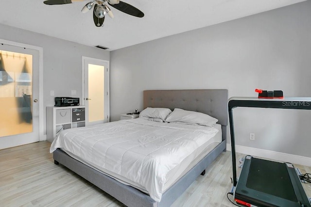 bedroom with light wood finished floors, ceiling fan, visible vents, and baseboards