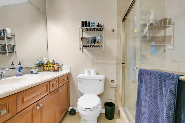 bathroom featuring toilet, a stall shower, vanity, and tile patterned floors