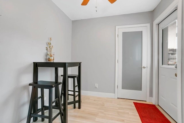 dining room featuring light wood-type flooring, baseboards, and a ceiling fan