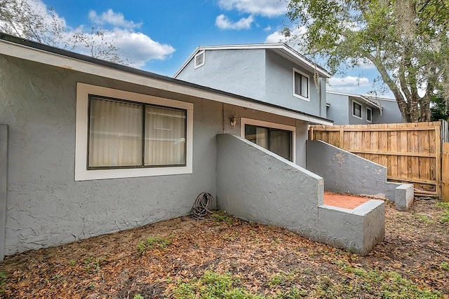 view of home's exterior featuring fence and stucco siding