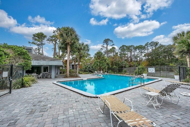 pool featuring fence and a patio