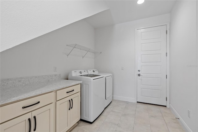 clothes washing area with separate washer and dryer, cabinets, and light tile floors