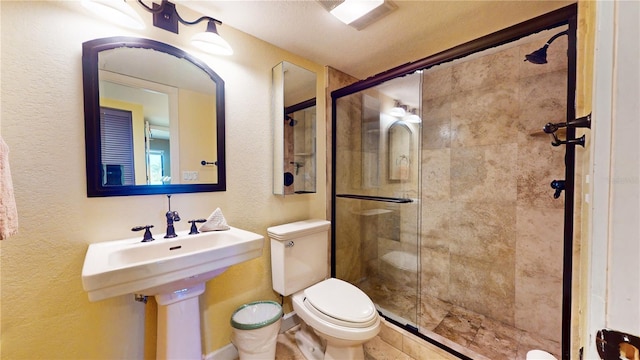 bathroom featuring a textured ceiling, an enclosed shower, and toilet