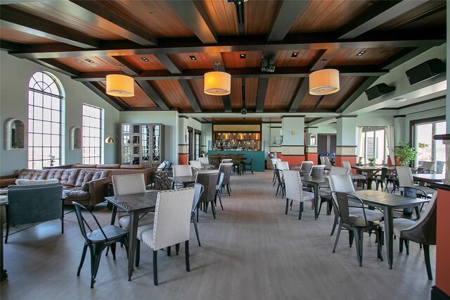 dining area featuring beam ceiling, hardwood / wood-style flooring, and wooden ceiling