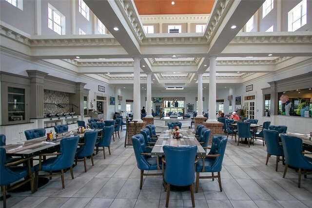 interior space featuring a towering ceiling, beamed ceiling, coffered ceiling, and ornamental molding