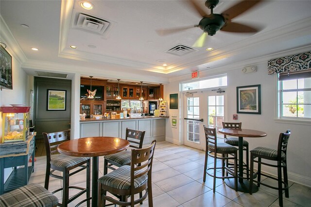 tiled dining room featuring french doors, ceiling fan, crown molding, and a tray ceiling