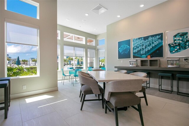 tiled dining space with a high ceiling