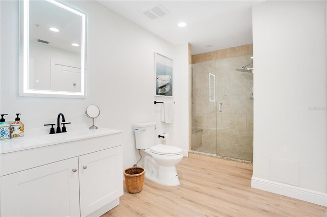 bathroom with vanity, hardwood / wood-style flooring, toilet, and a shower with shower door