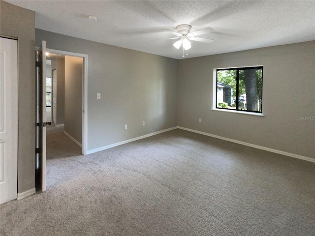 carpeted empty room with ceiling fan and a textured ceiling