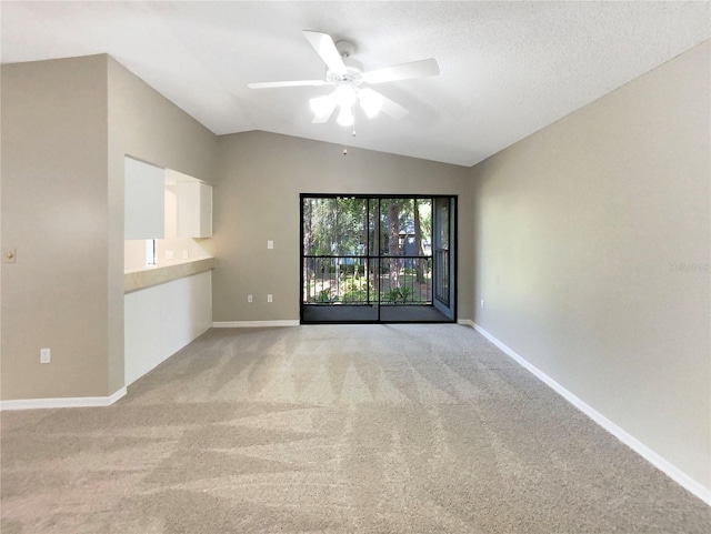 carpeted spare room with ceiling fan and lofted ceiling