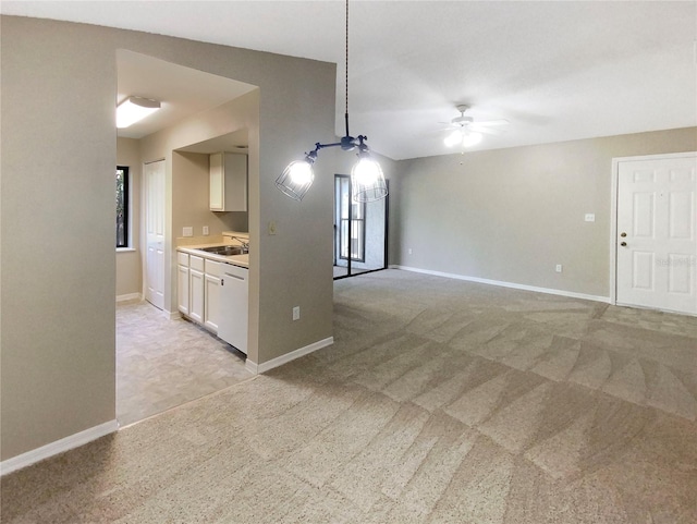 interior space featuring ceiling fan, light colored carpet, and sink