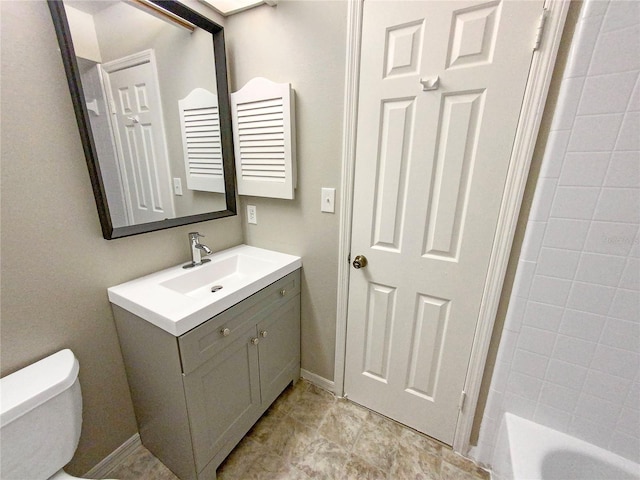 bathroom featuring tile flooring, vanity, and toilet