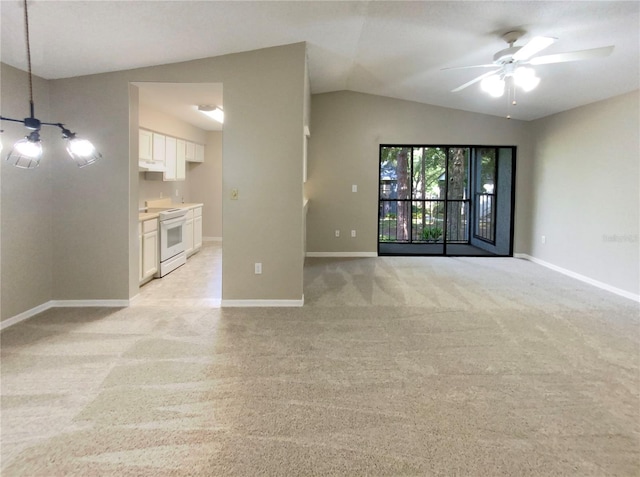 unfurnished living room with ceiling fan, light colored carpet, and lofted ceiling