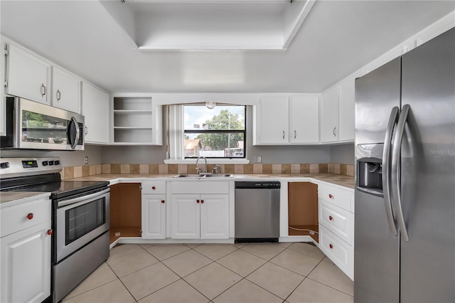 kitchen featuring stainless steel appliances, sink, white cabinetry, and light tile floors