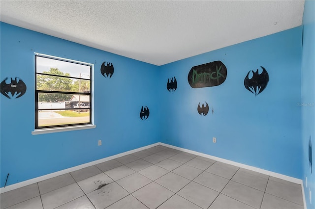 tiled spare room with a textured ceiling