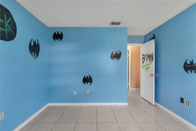 tiled spare room featuring a textured ceiling