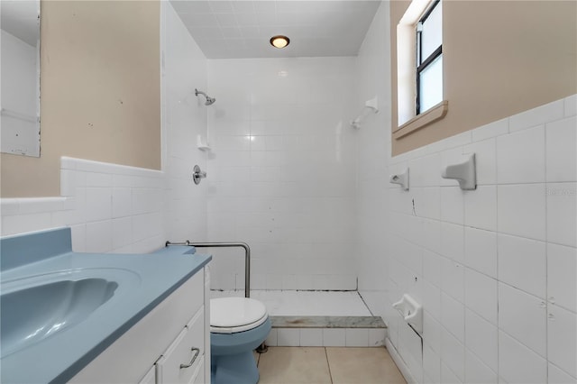 bathroom with tile walls, a tile shower, tile flooring, and toilet