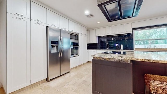 kitchen featuring white cabinets, appliances with stainless steel finishes, stone counters, and tasteful backsplash