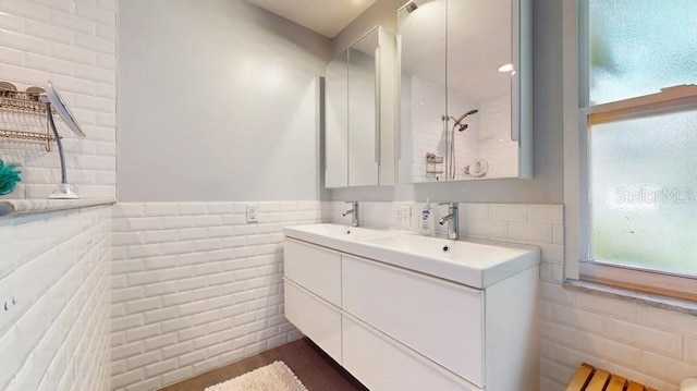 bathroom featuring brick wall and vanity