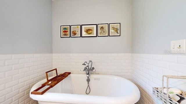 bathroom with tile walls and a bathtub