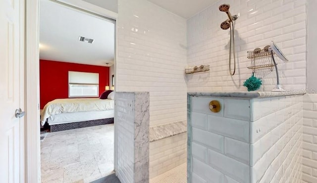 bathroom featuring tile floors, tiled shower, and brick wall