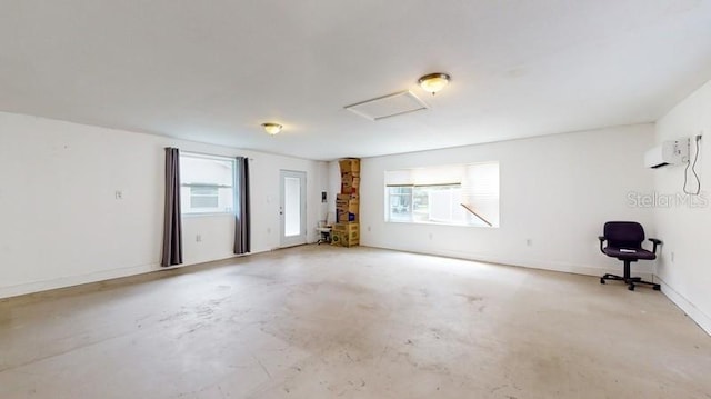 empty room featuring concrete flooring and an AC wall unit