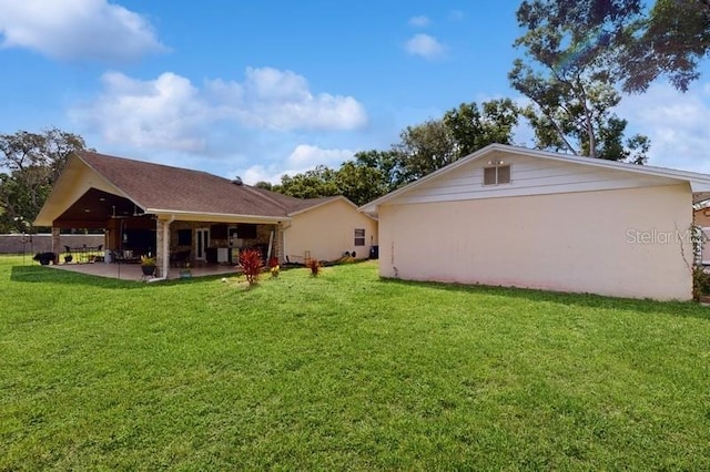 rear view of house featuring a patio and a lawn