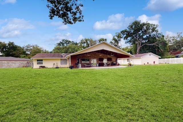 rear view of house with a patio and a lawn