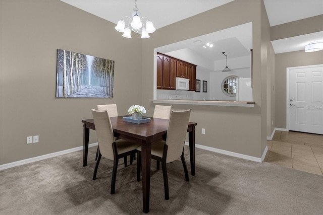 dining space with light carpet and a notable chandelier