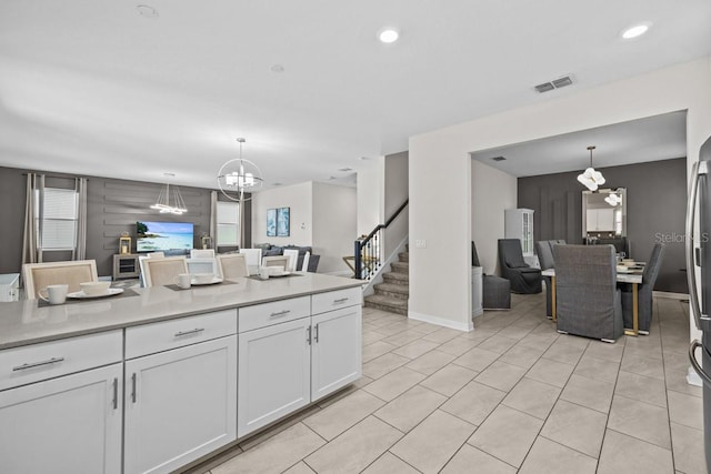 kitchen with decorative light fixtures, white cabinets, plenty of natural light, and an inviting chandelier