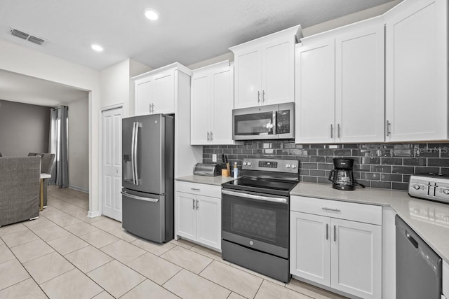 kitchen featuring appliances with stainless steel finishes, white cabinets, and tasteful backsplash