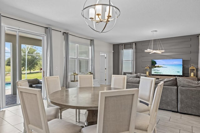 dining area featuring a wealth of natural light, a chandelier, and light tile floors