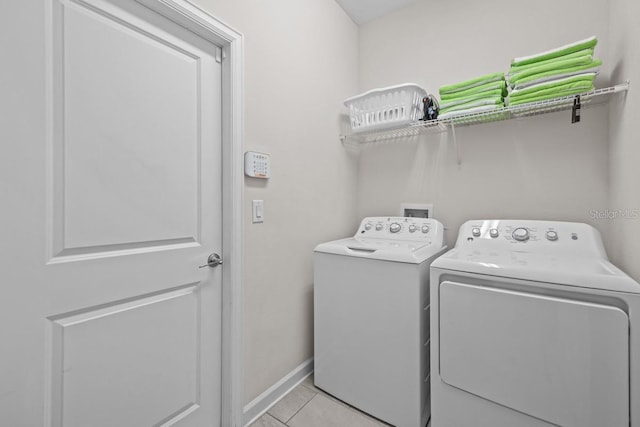 laundry area featuring washer and dryer, light tile flooring, and washer hookup