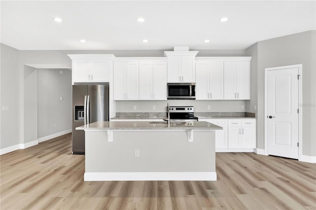 kitchen with white cabinetry, stainless steel appliances, a kitchen island with sink, and sink