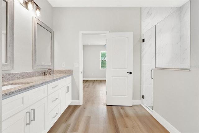 bathroom with hardwood / wood-style flooring, an enclosed shower, and vanity