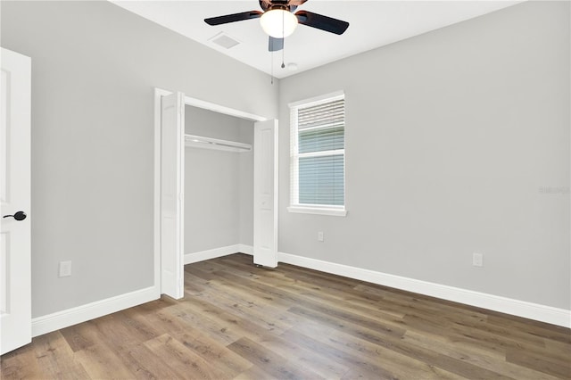 unfurnished bedroom featuring a closet, wood-type flooring, and ceiling fan