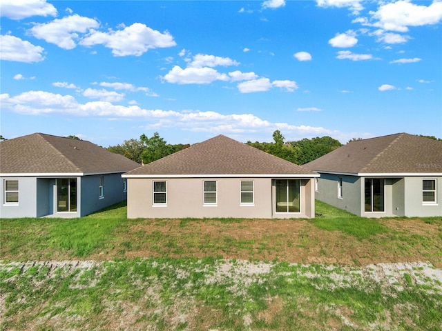 back of property featuring a lawn