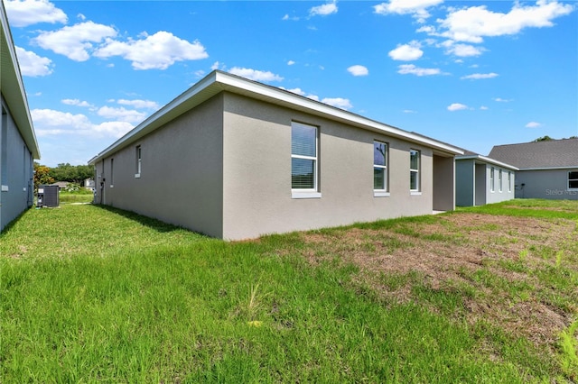 rear view of property featuring central AC unit and a lawn