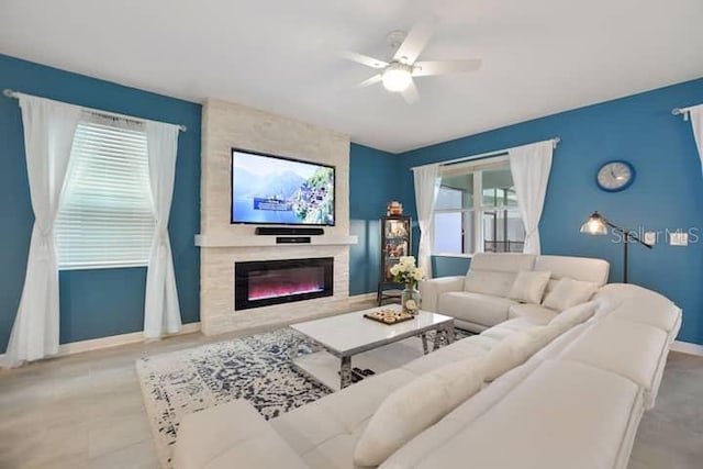 living room featuring ceiling fan and a fireplace