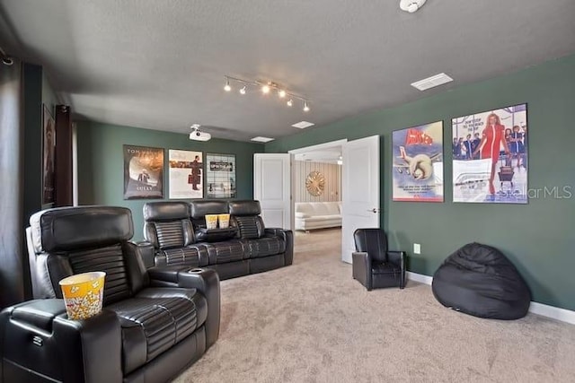 home theater featuring carpet floors, a textured ceiling, and track lighting