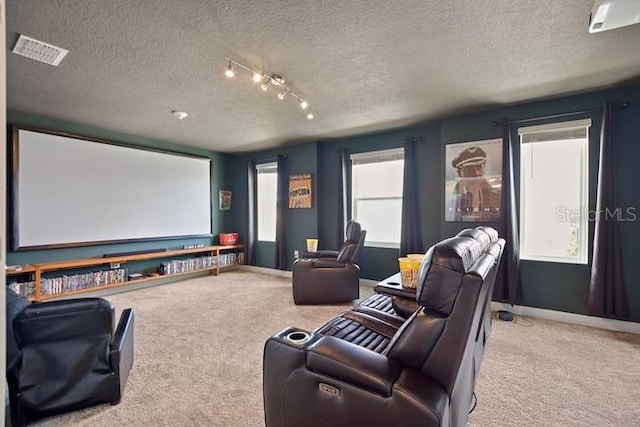 home theater with light colored carpet, a textured ceiling, and rail lighting