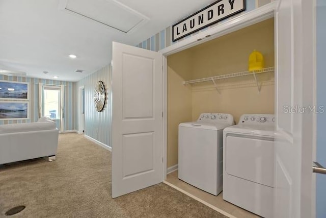 clothes washing area featuring light carpet and washer and clothes dryer