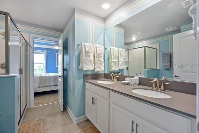 bathroom featuring vanity with extensive cabinet space, an enclosed shower, double sink, and tile flooring