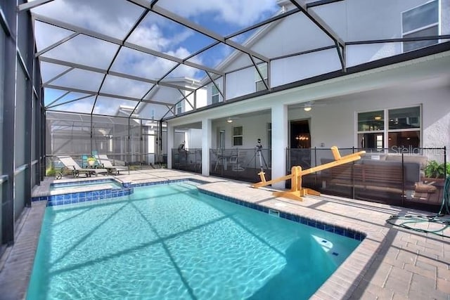 view of swimming pool featuring a patio, glass enclosure, and an in ground hot tub