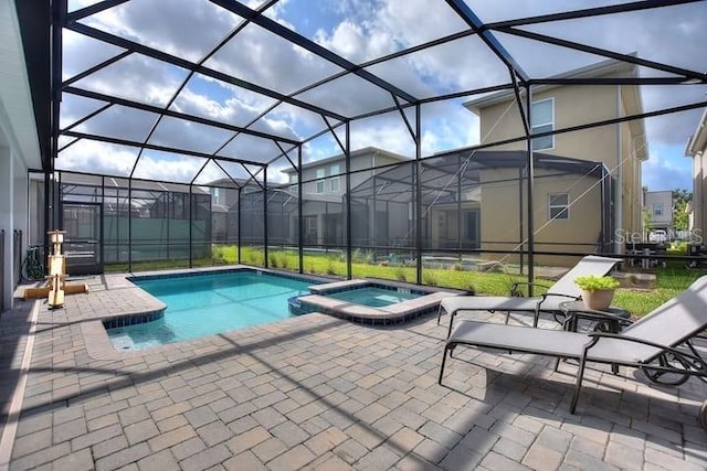 view of swimming pool with a patio, glass enclosure, and an in ground hot tub