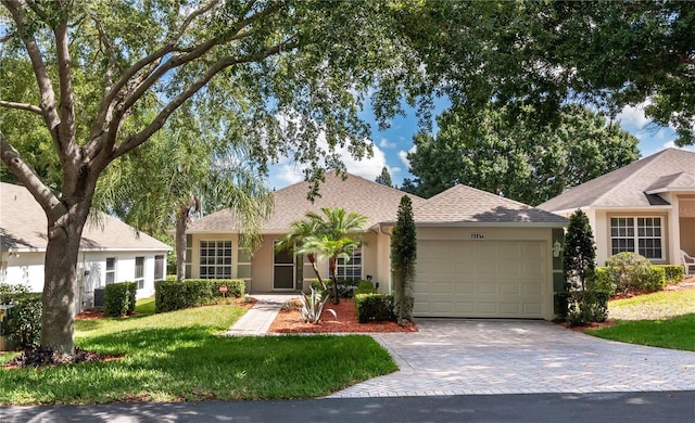 ranch-style home with a garage and a front lawn